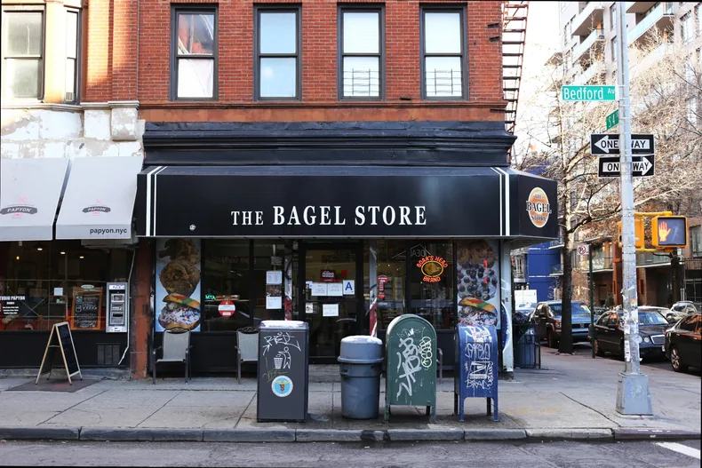 Brick-front neighborhood bagel shop on a city corner.